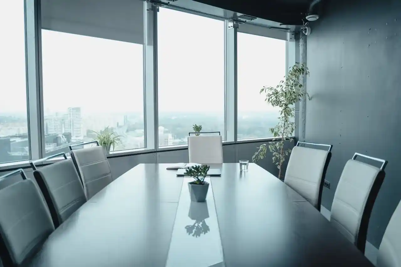 Trusted Partnerships - Close-up of two people in business suits shaking hands across a desk with documents/contracts visible on the table (shot from the side, focusing on the handshake)